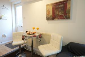 a room with two chairs and a table with two glasses at Cosy 3BR House, 2 Bath, Near Luton Centre in Luton