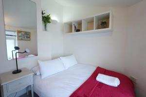 a bedroom with a white bed with a red blanket at Cosy 3BR House, 2 Bath, Near Luton Centre in Luton