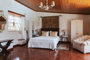 a bedroom with a bed and a chair in it at Horta da Fonte in Alburitel +108 photos