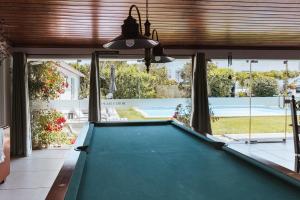 a pool table in a living room with a view of a swimming pool at Horta da Fonte in Alburitel