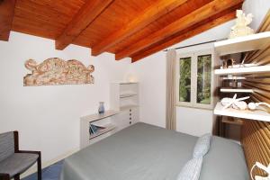 a bedroom with a bed and a desk and a window at Villa Silvia direttamente sul mare in Caronia Marina