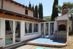 a patio with a fireplace in front of a house at Villa Silvia direttamente sul mare in Caronia Marina