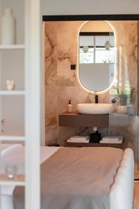 a bathroom with a sink and a mirror at Balsamia Boutique Apartments in Podčetrtek +69 photos