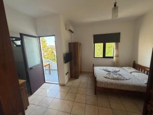 a bedroom with a bed and a sliding glass door at ApartHotel Fahria Velipoje in Velipojë