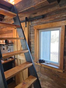 a staircase in a wooden cabin with a window at Cozy Bethel Barn in Mongaup Valley