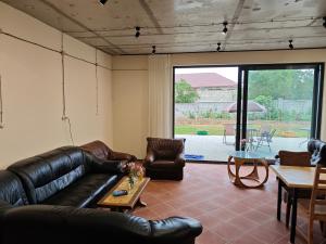 a living room with a leather couch and a table at Hotel Manglisi Hills in Manglisi