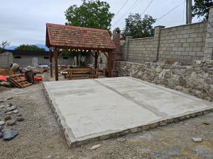 a concrete slab with a pavilion next to a stone wall at Hotel Manglisi Hills in Manglisi