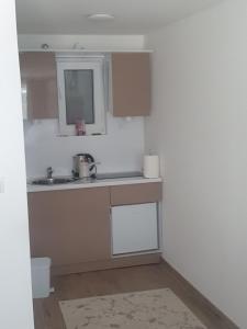 a kitchen with a sink and a mirror at Apartmani Zoka in Niš +9 photos