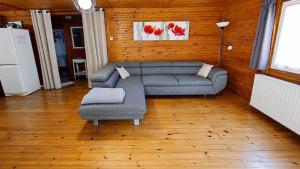 a living room with a couch and a chair at Le chalet du mazagran in Leffincourt