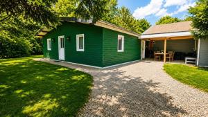 a green cottage with a table in the yard at Le chalet du mazagran in Leffincourt