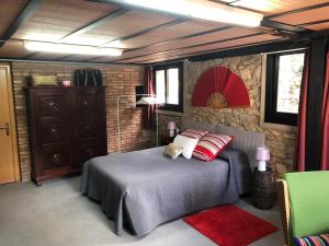 a bedroom with a bed and a stone wall at Era Cal Anton in Alás