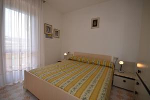 ビビオーネにあるAppartamenti Diana Estのベッドルーム1室(黄色い掛け布団、窓付)