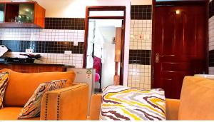 a living room with an orange couch in a kitchen at Toquee Hotel Bookings - Nairobi in Nairobi