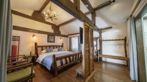 a bedroom with a large bed and wooden beams at 佬树客栈 Big Tree Guesthouse - Free Laundry & Coffee in Lijiang
