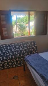 a bedroom with a bed and a window with a view at Apartamento in Jericoacoara