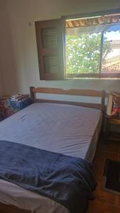 a bed sitting in a bedroom with a window at Apartamento in Jericoacoara