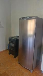 a stainless steel refrigerator in a kitchen next to a stove at Apartamento in Jericoacoara