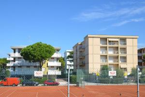 ビビオーネにあるAppartamenti Diana Estの建物の前に車を停めたテニスコート
