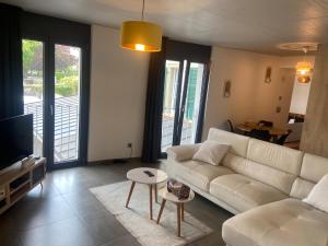 a living room with a white couch and a table at Bulle de rêve jacuzzi in Bulle