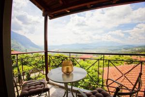 a table and chairs on a balcony with a view at The Stone Alley in Konitsa +5 photos