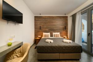 a bedroom with a bed with two towels on it at Angelo Boutique Hotel Santorini in Perissa