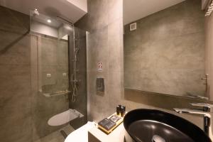 a bathroom with a black sink and a shower at Angelo Boutique Hotel Santorini in Perissa +57 photos