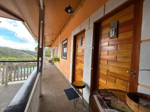 a room with a balcony with a table and a window at SkyBlue Guesthouse by Concavus in Campos do Jordão