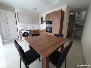 una cocina y comedor con mesa y sillas de madera en Marbella Holiday Apartments - Seafront - Wifi, en Marsaskala 5 fotos más