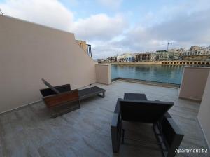 un balcón con vistas al agua en Marbella Holiday Apartments - Seafront - Wifi, en Marsaskala
