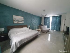 un dormitorio con una cama y una silla dentro en Marbella Holiday Apartments - Seafront - Wifi, en Marsaskala