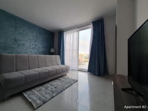 una sala de estar con un sofá y una ventana grande en Marbella Holiday Apartments - Seafront - Wifi, en Marsaskala