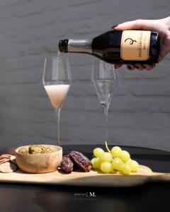 a person pouring a bottle of wine into a glass at Atelier M in Kruisem