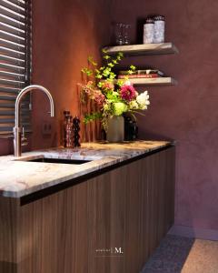 a kitchen with a sink and a vase of flowers at Atelier M in Kruisem