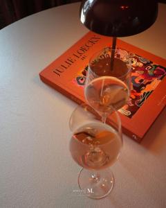 a wine glass sitting on a table next to a book at Atelier M in Kruisem