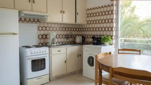a kitchen with white appliances and a table and a window at Kineta Prime Suites No2 in Kineta +19 photos