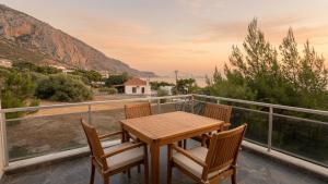 a wooden table and chairs on a balcony with a view at Kineta Prime Suites No2 in Kineta