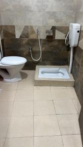 a bathroom with a toilet and a sink in the floor at Abu Khalid By MZ Hotels & Restaurant in Mingāora