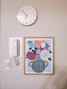 a clock on a wall with a picture of a teapot at Toyo Yoyoginumi in Tokyo