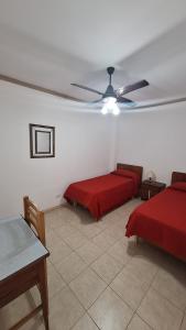 a bedroom with two beds and a ceiling fan at Hotel 7 De Septiembre in San Clemente del Tuyú