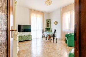 a living room with a table and chairs and a television at Apartment Superiore a 950 metri dal mare in Albisola Superiore