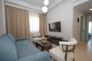 a living room with a blue couch and chairs at Grand Blue Beach Hotel in Kardamaina