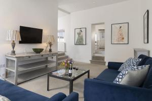 a living room with two blue couches and a tv at The Haven in Chipping Norton