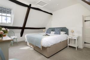 a bedroom with a bed with blue and white pillows at The Haven in Chipping Norton