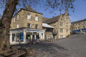 an old brick building on a street with a bench at The Haven in Chipping Norton