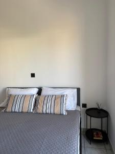 a bedroom with a bed with two pillows and a table at Suva Apartments Chania in Agia Marina Nea Kydonias