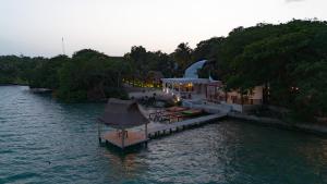 a resort on a river with a dock in the water at GlampCalar lagoon Front Bungalows in Rancho Bacalar