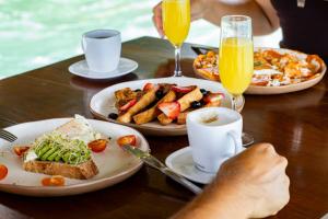 a table topped with plates of food and drinks at GlampCalar lagoon Front Bungalows in Rancho Bacalar