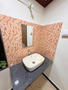 a bathroom with a sink and a mirror at Shree Kelbai Homestay in Malvan