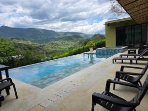 a pool with chairs and a view of the mountains at Casa Mezcal in Villeta