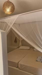 a white bed with a canopy in a room at Suíte privada in Jericoacoara
